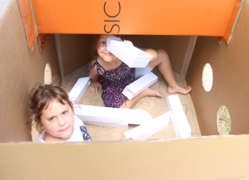 ילדות משחקות עם פריסקופ בתוך צוללת מקרטון ביום הולדת מדעי