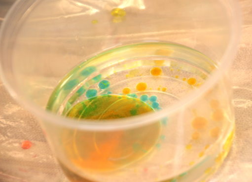 טיפות מים צבעוניים בקערה עם שמן ביום הולדת מדעי
