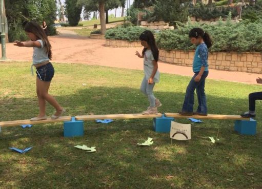 יום הולדת קשת בענן | ילדות חוצות את קורת עץ בתחנת גשר הקסמים