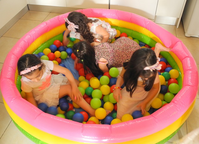 ילדות מחפשות את המטמון בבריכת כדורים ביום הולדת כלבלבים