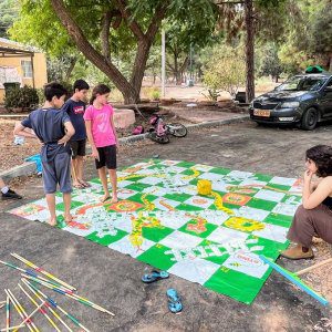 ילדים משחקים במשחק סולמות ונחשים ענק